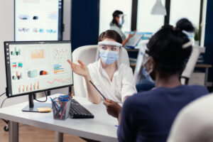 Healthcare employee showing data to a patient with dashboard on desktop - Power BI for Healthcare/pharma industry